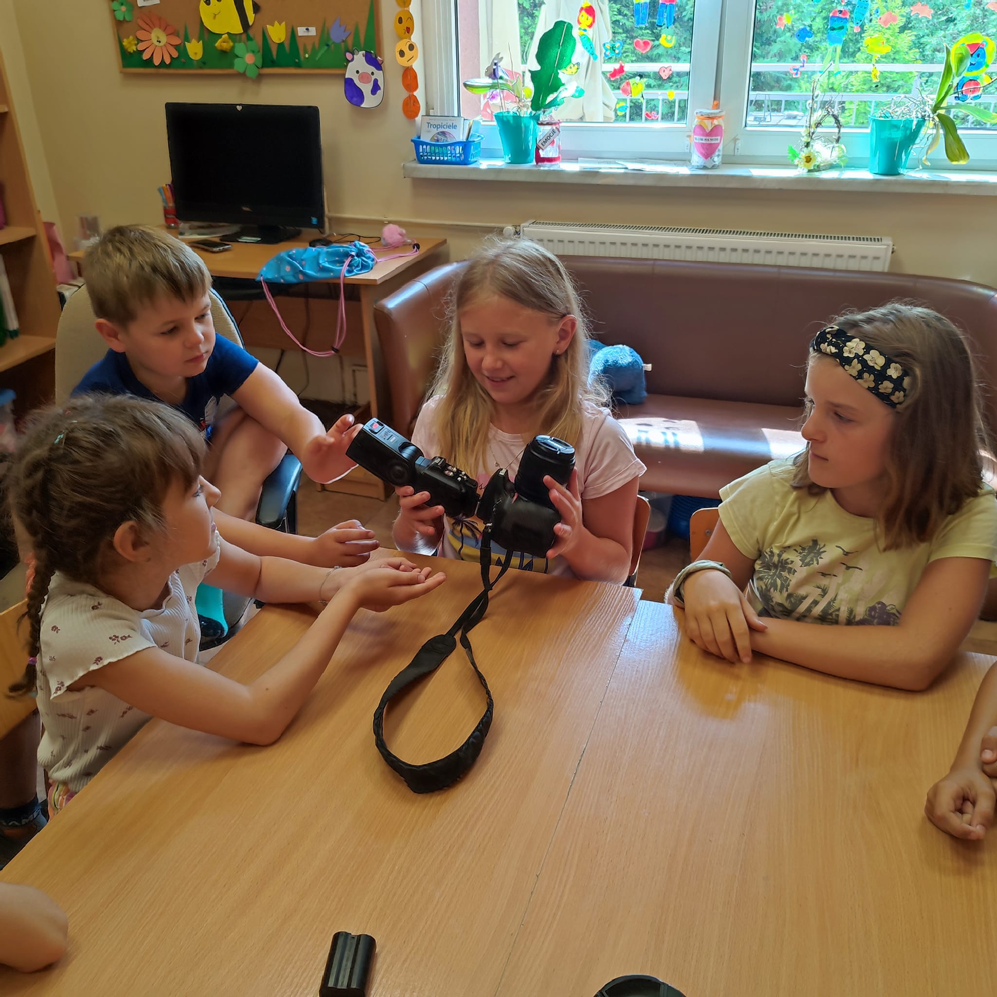 Dzieci oglądaja aparat fotograficzny