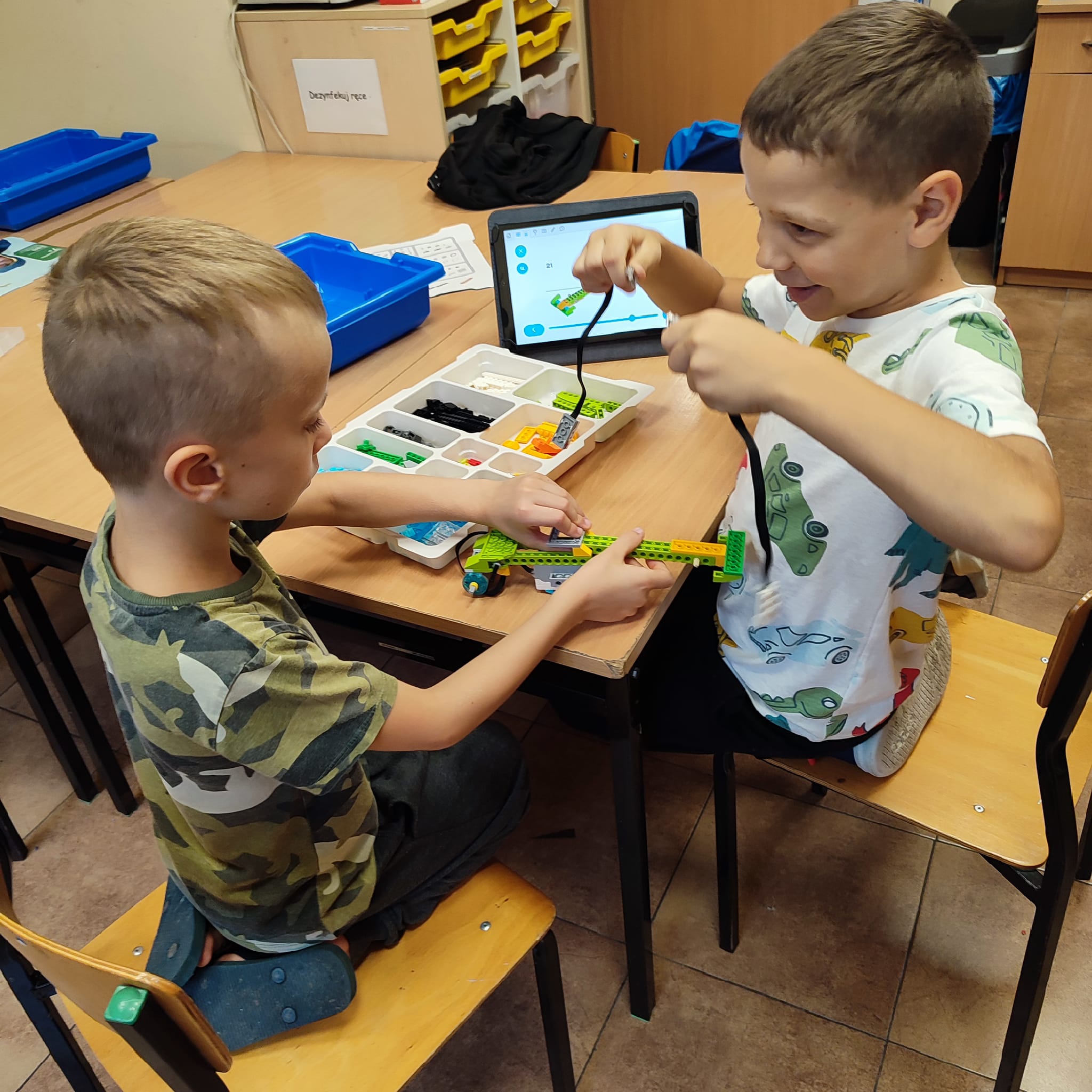 Dwóch chłopców układa pojazd z klocków lego Dwóch chłopców układa pojazd z klocków lego