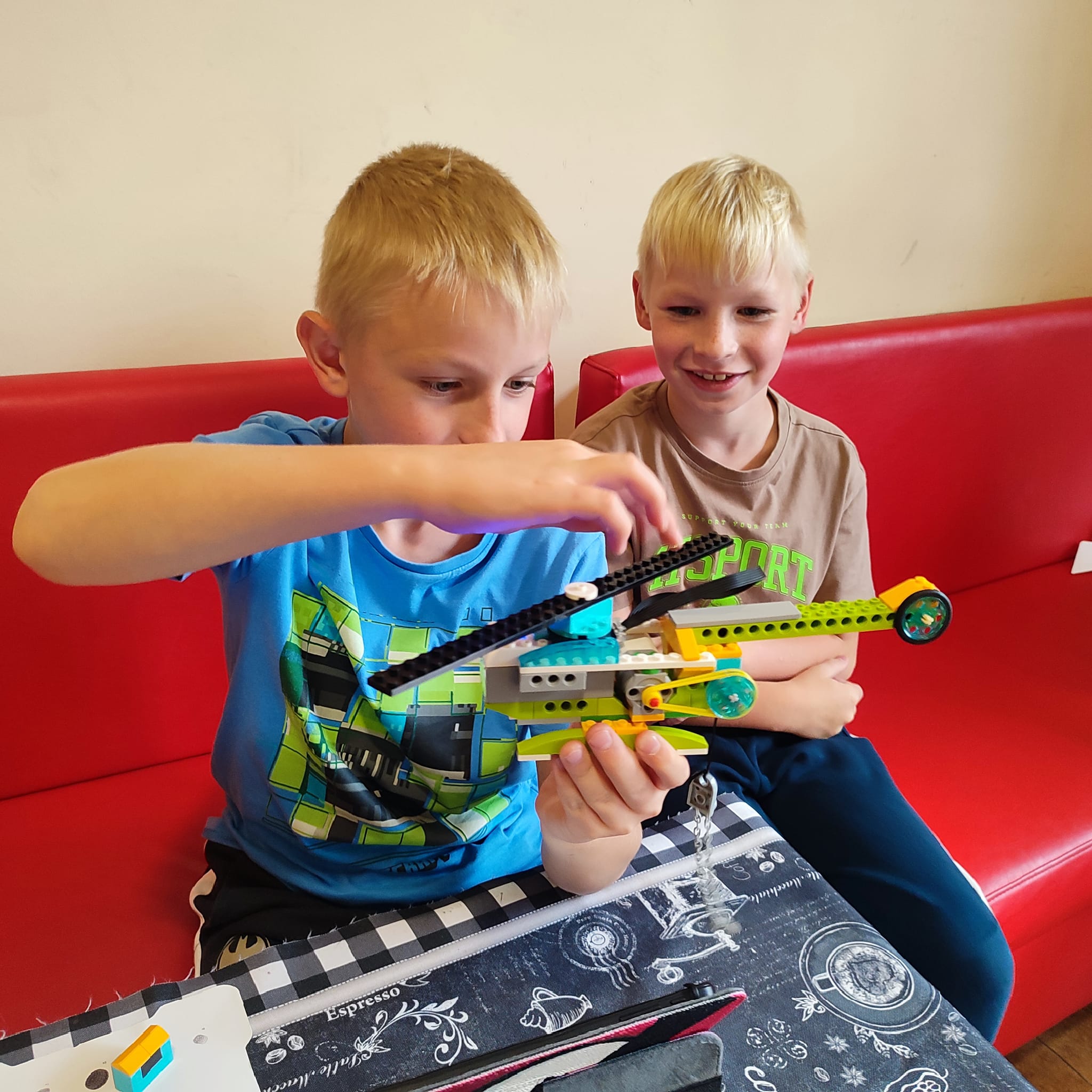 Dwóch chłopców układa samolot z klocków lego Dwóch chłopców układa samolot z klocków lego